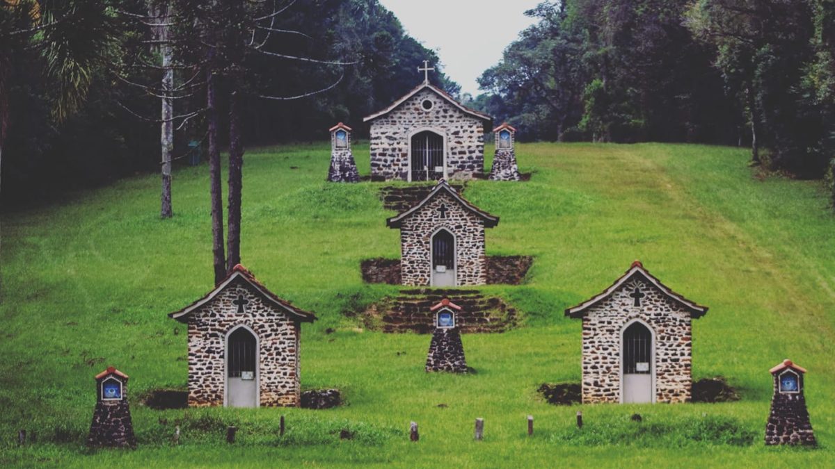Ao longo de um corredor de grama baixa, cercado por muitas árvores, 14 capelinhas feitas de pedra contam a história de um imigrante português que viveu no Paraná.